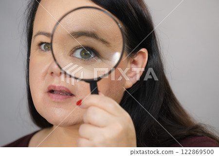 Adult woman with magnifying glass 122869500