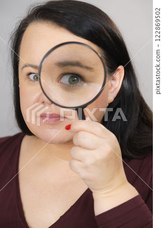 Adult woman with magnifying glass 122869502