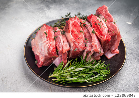 Raw Beef Kalbi Short Ribs, fresh meat with bone on plate with thyme. grey background. top view Raw Beef Kalbi Short Ribs, fresh meat with bone on plate with thyme. grey background. top view 122869842