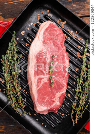 Fresh strip loin beef steak, striploin steak on a grill pan wooden background. top view 122869844