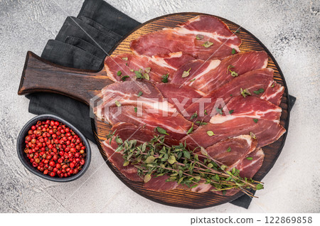 Guanciale dried speck ham, pork cured meat on wooden board. grey background. top view 122869858