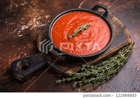 Tomato sauce passata in a skillet , traditional recipe of italian cuisine. brown background. top view Tomato sauce passata in a skillet , traditional recipe of italian cuisine. brown background. top view 122869883