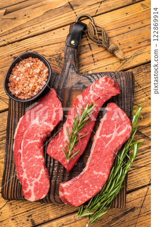 Raw marbled beef Steak, beef meat on wooden board with herbs. wooden background. top view 122869914