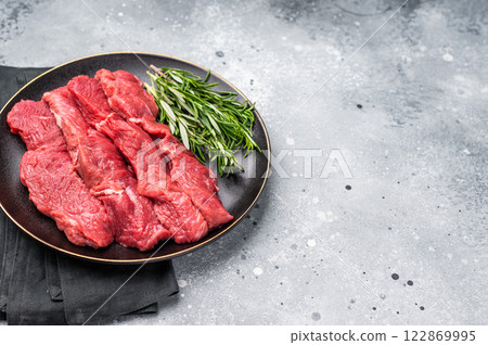 Raw bison meat presented with fresh herbs and spices, inspiring bold flavors and unique recipes for adventurous food lovers. grey background. top view Raw bison meat presented with fresh herbs and spices, inspiring bold flavors and unique recipes for adventurous food lovers. grey background. top view 122869995