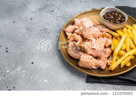 Dinner with Pulled salmon roast fillets and french fry on a plate. gray background. Top view 122870002