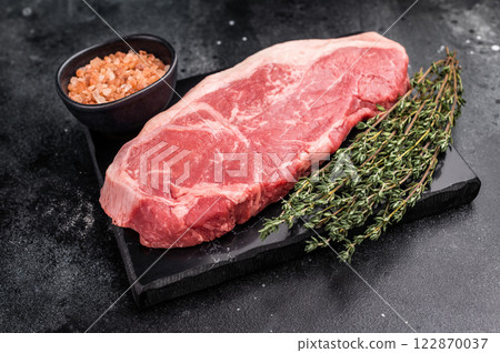 Raw striploin beef steak, New York strip steak. black background. top view Raw striploin beef steak, New York strip steak. black background. top view 122870037