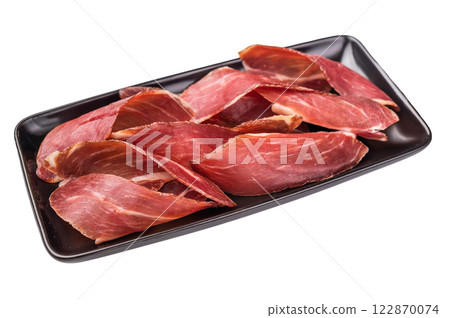 Serbian ham Prsut, sliced cured pork meat on plate isolated on white background. top view 122870074