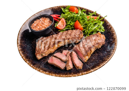 BBQ Grilled skirt or machete Steak, beef meat on a plate with salad isolated on white background 122870099
