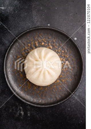 Chinese Steam Bao bun with meat on plate with chopsticks. black background. top view 122870104