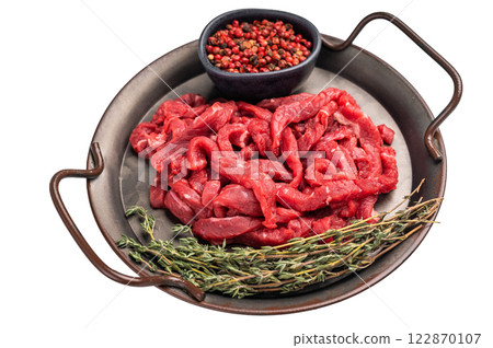 Beef sliced meat, raw veal strips for cooking beef stroganoff on a steel tray isolated on white background Beef sliced meat, raw veal strips for cooking beef stroganoff on a steel tray isolated on white background 122870107
