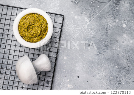 Pesto sauce, Iitalian spread with green basil in bowl. grey background. top view. Pesto sauce, Iitalian spread with green basil in bowl. grey background. top view. 122870113