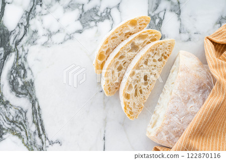 Italian baked and sliced ciabatta bread on a marble table. marble background. top view Italian baked and sliced ciabatta bread on a marble table. marble background. top view 122870116