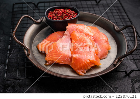 Salty salmon, trout fillet slices on steel tray. black background. top view Salty salmon, trout fillet slices on steel tray. black background. top view 122870121