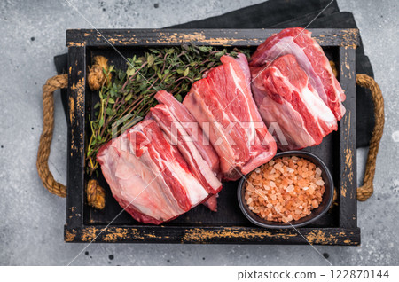 Fresh Raw lamb rib cuts, mutton meat with rib bone in wooden board. grey background. top view Fresh Raw lamb rib cuts, mutton meat with rib bone in wooden board. grey background. top view 122870144