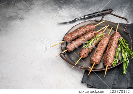 Grilled Cevapcici ready for the grill, roast Cevapi from mince beef meat. grey background. top view Grilled Cevapcici ready for the grill, roast Cevapi from mince beef meat. grey background. top view 122870332