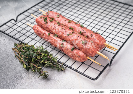 Raw kofta or lula kebabs skewers from mince lamb and beef meat on Skewer. grey background. top view 122870351