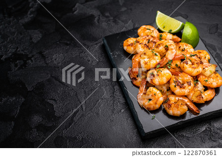 BBQ Roasted spicy Shrimps Prawns with garlic. Black background. Top view BBQ Roasted spicy Shrimps Prawns with garlic. Black background. Top view 122870361