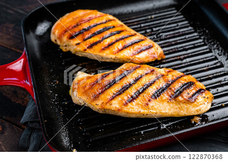 Roasted on grill pan Chicken breasts, fried poultry meat steaks, top view, wooden background. Roasted on grill pan Chicken breasts, fried poultry meat steaks, top view, wooden background. 122870368