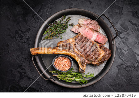 Roasted Tomahawk beef steak, roast dry aged rib eye with bone. black background. top view 122870419