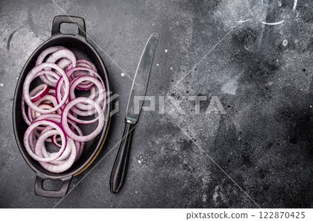 Fresh Raw onion rings in skillet. black background. top view Fresh Raw onion rings in skillet. black background. top view 122870425