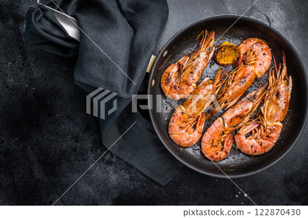 Pan fried red Argentine shrimps, Prawns Langostino Austral with herbs. black background. top view 122870430