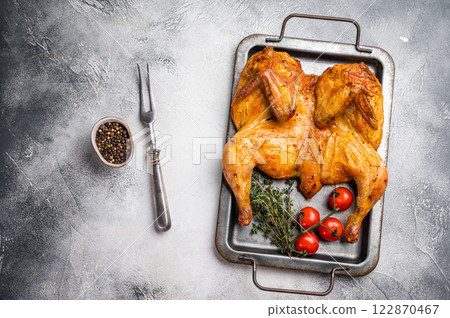 Baked chicken Tabaka with spices, poultry meat on steel tray. white background. top view Baked chicken Tabaka with spices, poultry meat on steel tray. white background. top view 122870467