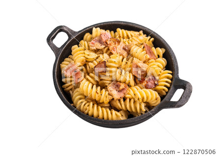 Fusilli delicious carbonara pasta topped with crispy bacon bits and fresh herbs in a skillet isolated on white background Fusilli delicious carbonara pasta topped with crispy bacon bits and fresh herbs in a skillet isolated on white background 122870506