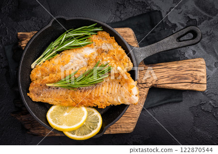 Pan Fried Hake white fish fillet. black background. top view 122870544
