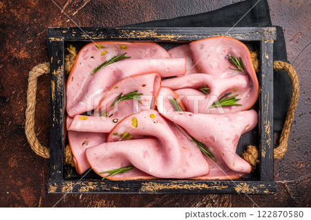 Mortadella Bologna slices with pistachios for breakfast in wooden. brown background. top view Mortadella Bologna slices with pistachios for breakfast in wooden. brown background. top view 122870580