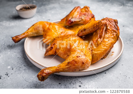 Roasted Spatchcock Chicken, poultry meat. grey background. top view Roasted Spatchcock Chicken, poultry meat. grey background. top view 122870588