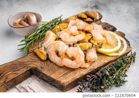 Fresh Seafood cocktail, raw Mix with Mussels, Clams, Prawns, Shrimps and squid on wooden board. white background. top view Fresh Seafood cocktail, raw Mix with Mussels, Clams, Prawns, Shrimps and squid on wooden board. white background. top view 122870604