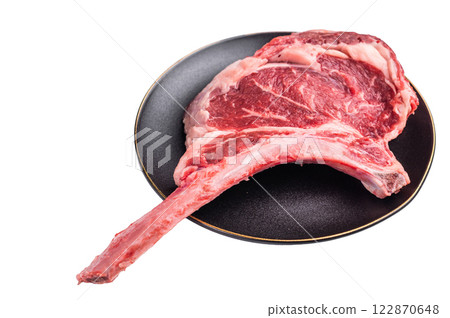 Fresh Tomahawk beef steak, raw marbled rib eye with bone on plate with herbs Isolated on a white background. top view Fresh Tomahawk beef steak, raw marbled rib eye with bone on plate with herbs Isolated on a white background. top view 122870648