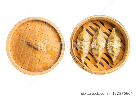 Steamed Korean dumplings with pork meat and vegetables in bamboo steamer isolated on white background. top view Steamed Korean dumplings with pork meat and vegetables in bamboo steamer isolated on white background. top view 122870664