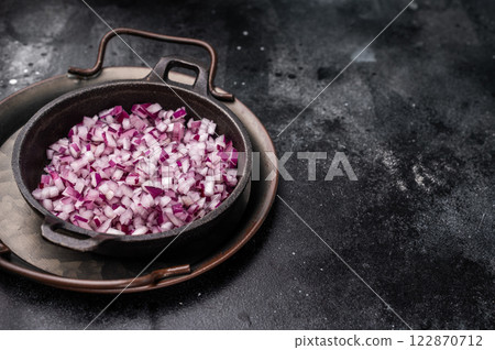 Chopped Red onion slices in steel tray. black background. top view 122870712