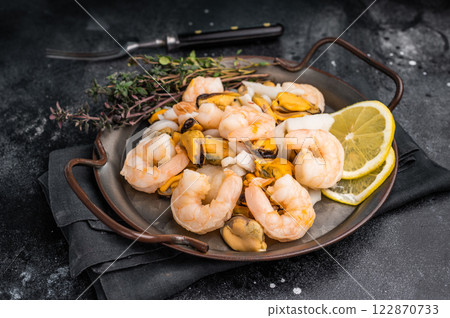 Fresh Seafood Mix with Mussels, Clams, Prawns, Shrimps and squid. black background. top view Fresh Seafood Mix with Mussels, Clams, Prawns, Shrimps and squid. black background. top view 122870733
