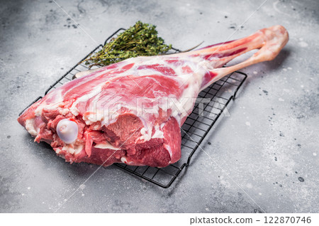 Raw whole lamb leg, fresh mutton meat. grey background. top view Raw whole lamb leg, fresh mutton meat. grey background. top view 122870746