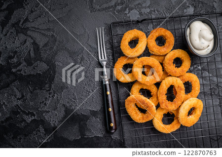 Ready or eat Deep Fried crunchy onion rings, delicious snack. black background. top view 122870763