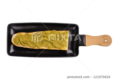Delicious green pesto spread on toasted bread, garnished with herbs isolated on white background Delicious green pesto spread on toasted bread, garnished with herbs isolated on white background 122870826