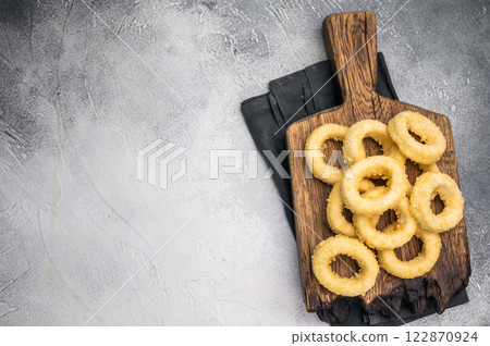 Raw and frozen squid rings with breading, uncooked calamari snack. white background. top view Raw and frozen squid rings with breading, uncooked calamari snack. white background. top view 122870924