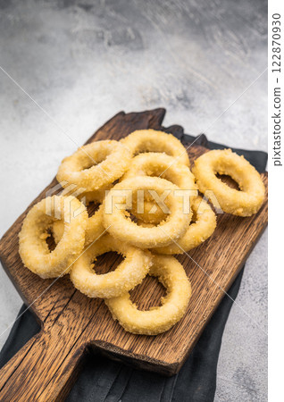 Raw and frozen squid rings with breading, uncooked calamari snack. white background. top view Raw and frozen squid rings with breading, uncooked calamari snack. white background. top view 122870930