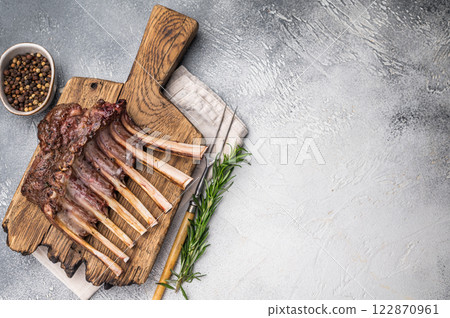 Grilled Rack of lamb, mutton meat chop steaks on wooden board. grey background. top view Grilled Rack of lamb, mutton meat chop steaks on wooden board. grey background. top view 122870961