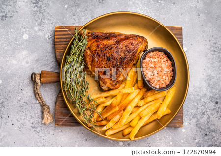 BBQ roast chicken thigh with french fry on a plate, poultry meat. grey background. top view BBQ roast chicken thigh with french fry on a plate, poultry meat. grey background. top view 122870994