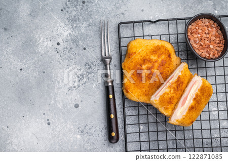 Fried Chicken cordon bleu cutlet with cheese and ham in breadcrumbs. grey background. top view 122871085