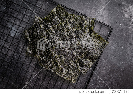 Dried Nori seaweed sheets on a rack. black background. top view 122871153