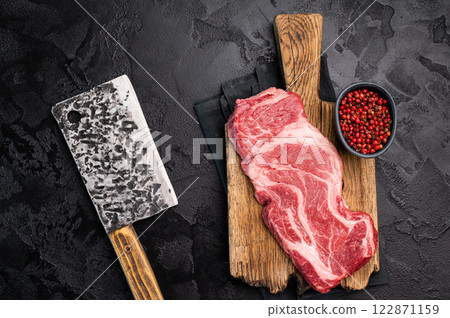 Uncooked Raw Chuck eye roll steak, prime beef meat on wooden board. black background. top view Uncooked Raw Chuck eye roll steak, prime beef meat on wooden board. black background. top view 122871159