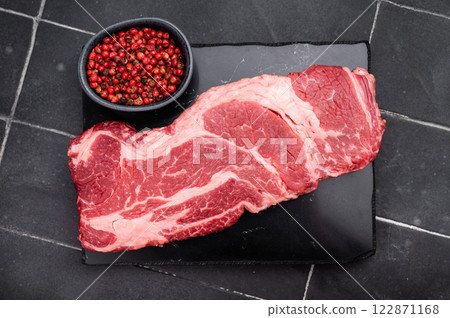 Raw Chuck eye roll steak, fresh prime beef meat. black background. top view Raw Chuck eye roll steak, fresh prime beef meat. black background. top view 122871168