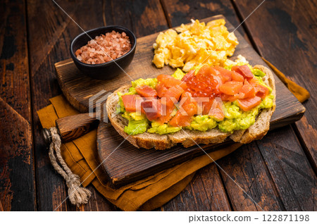 Sandwich with smoked salmon, trout, avocado and red caviar. wooden background. top view Sandwich with smoked salmon, trout, avocado and red caviar. wooden background. top view 122871198