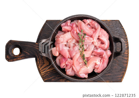 Raw Chicken sliced thighs fillets in a skillet isolated on white background Raw Chicken sliced thighs fillets in a skillet isolated on white background 122871235