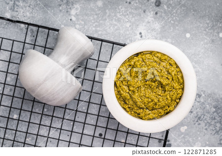 Pesto sauce, Iitalian spread with green basil in bowl. grey background. top view. 122871285