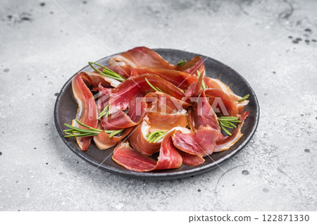 Meat appetizer dried duck breast fillet meat slices, magret smoked poultry. grey background. top view Meat appetizer dried duck breast fillet meat slices, magret smoked poultry. grey background. top view 122871330